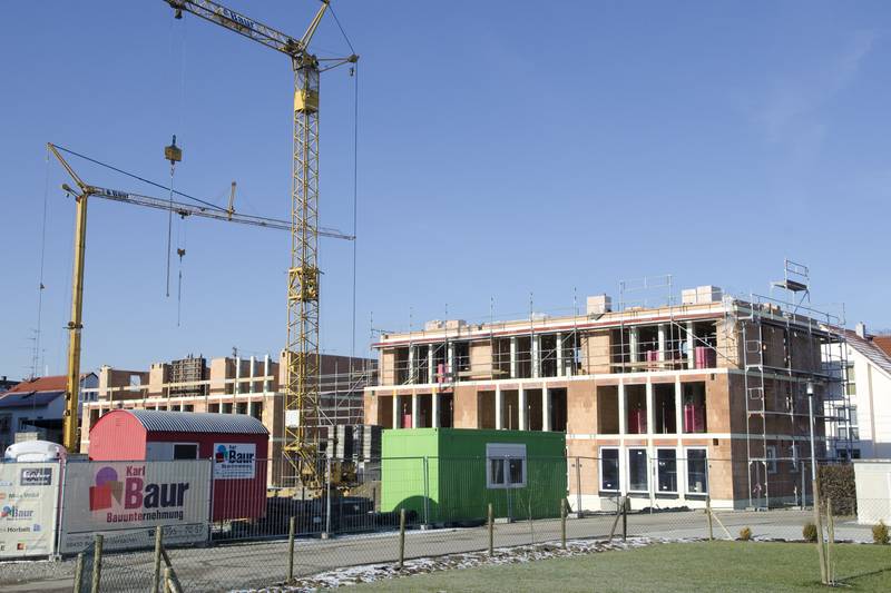Rohbau des Mehrfamilienhauses „Wohnen am Lerchenfeld“ mit Turmdrehkran und Baustellenschild der Firma Baur